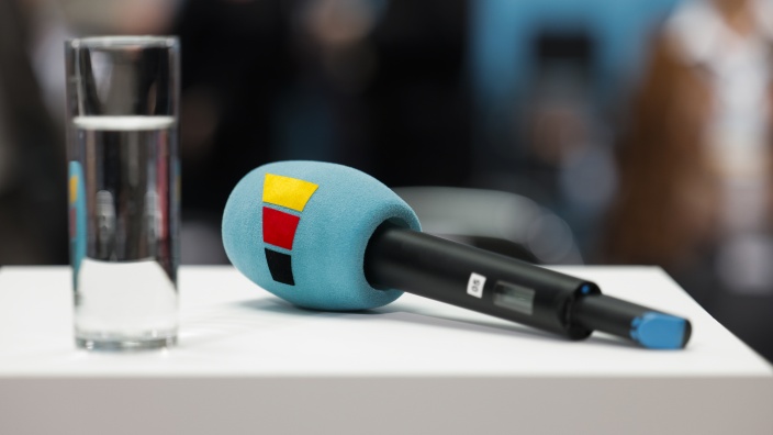 Ein Mikrofon mit CDU-Logo auf einem Tisch in einem Saal