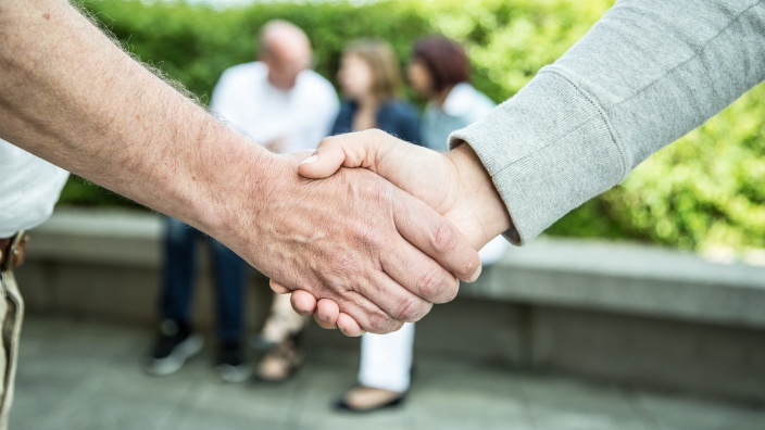 Zwei Menschen schütteln sich die Hände